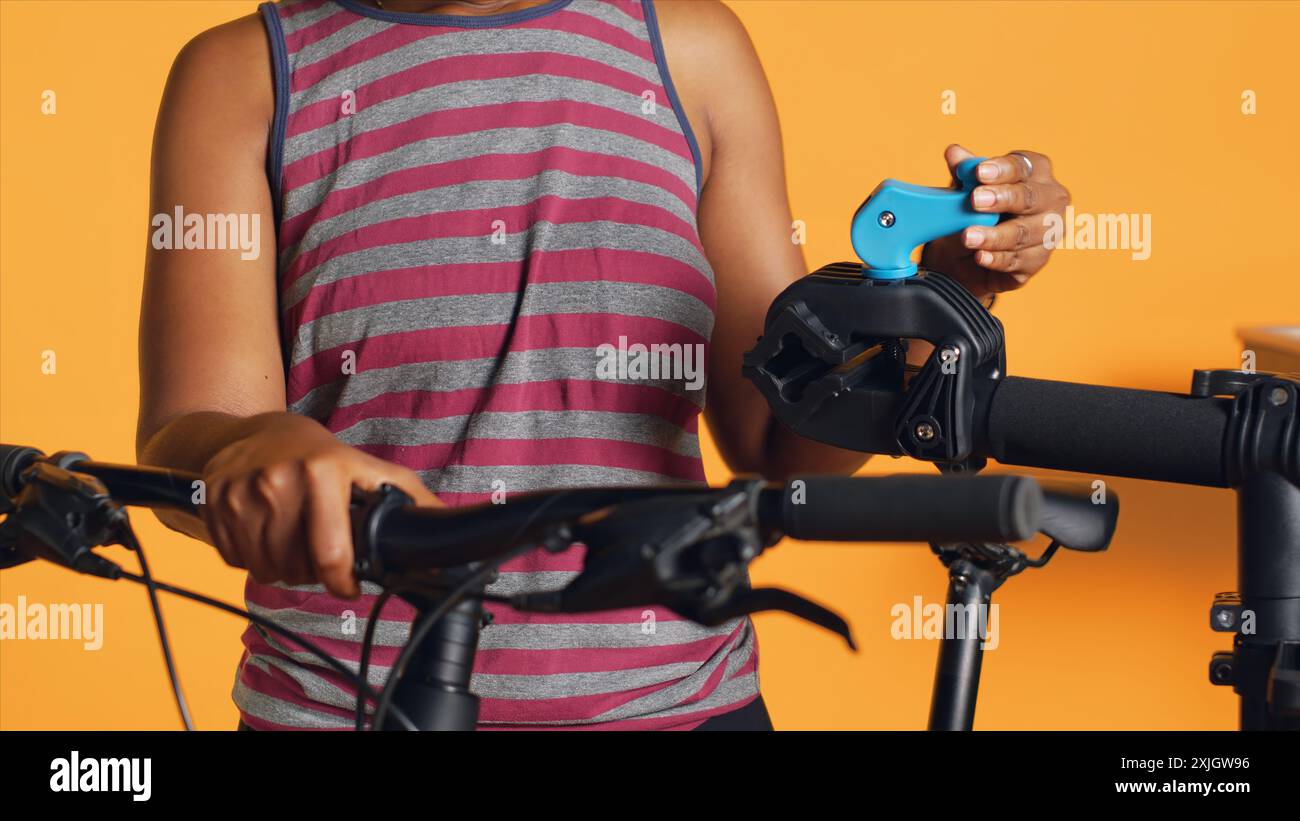 Il tecnico dell'assistenza prepara il cavalletto per la riparazione della moto prima di iniziare a lavorare su ruote difettose, sfondo dello studio. Preparazione professionale del banco di lavoro per biciclette prima dell'ispezione, primo piano Foto Stock