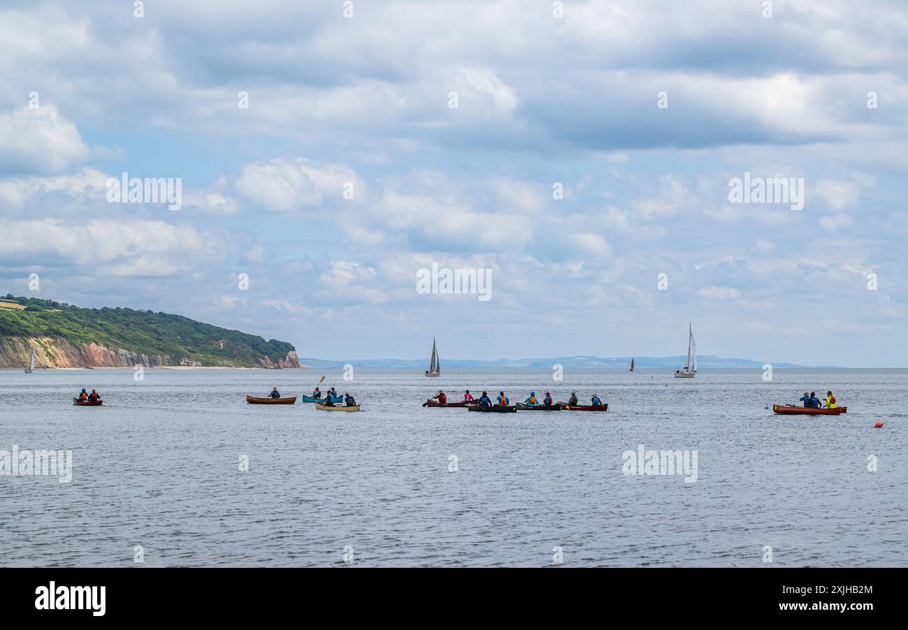 Persone in canoa sulla Seaton Bay con la spiaggia naturale di Haven Cliffs sullo sfondo, Jurassic Coast, Seaton, Devon, Inghilterra Foto Stock