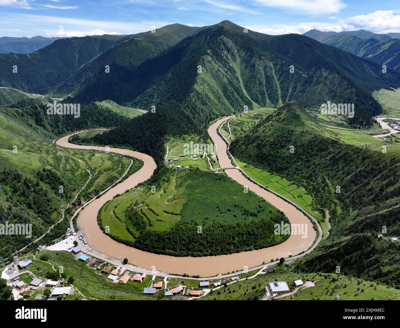 18 luglio 2024. Foto aerea della fattoria forestale del fiume Makho. La Makho River Forest Farm si trova nella contea di Banma, nella prefettura autonoma tibetana di Golog, nella provincia del Qinghai. Si trova nella riserva naturale nazionale di Sanjiangyuan con un'altitudine media di 3.600 metri. È la più alta fattoria di foresta vergine naturale in Cina. Il fiume Makho che attraversa l'area forestale è una delle sorgenti del fiume Dadu, un importante affluente del fiume Yangtze. Credito: Ma Mingyan/China News Service/Alamy Live News Foto Stock