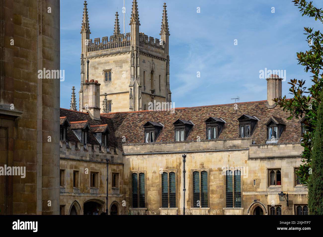 Cambridge, Regno Unito - 8 ottobre 2023: Un edificio storico con un'alta torre e finestre dormitori a Cambridge, Regno Unito. I muri di pietra e i tetti piastrellati sono un vero e proprio gioiello Foto Stock