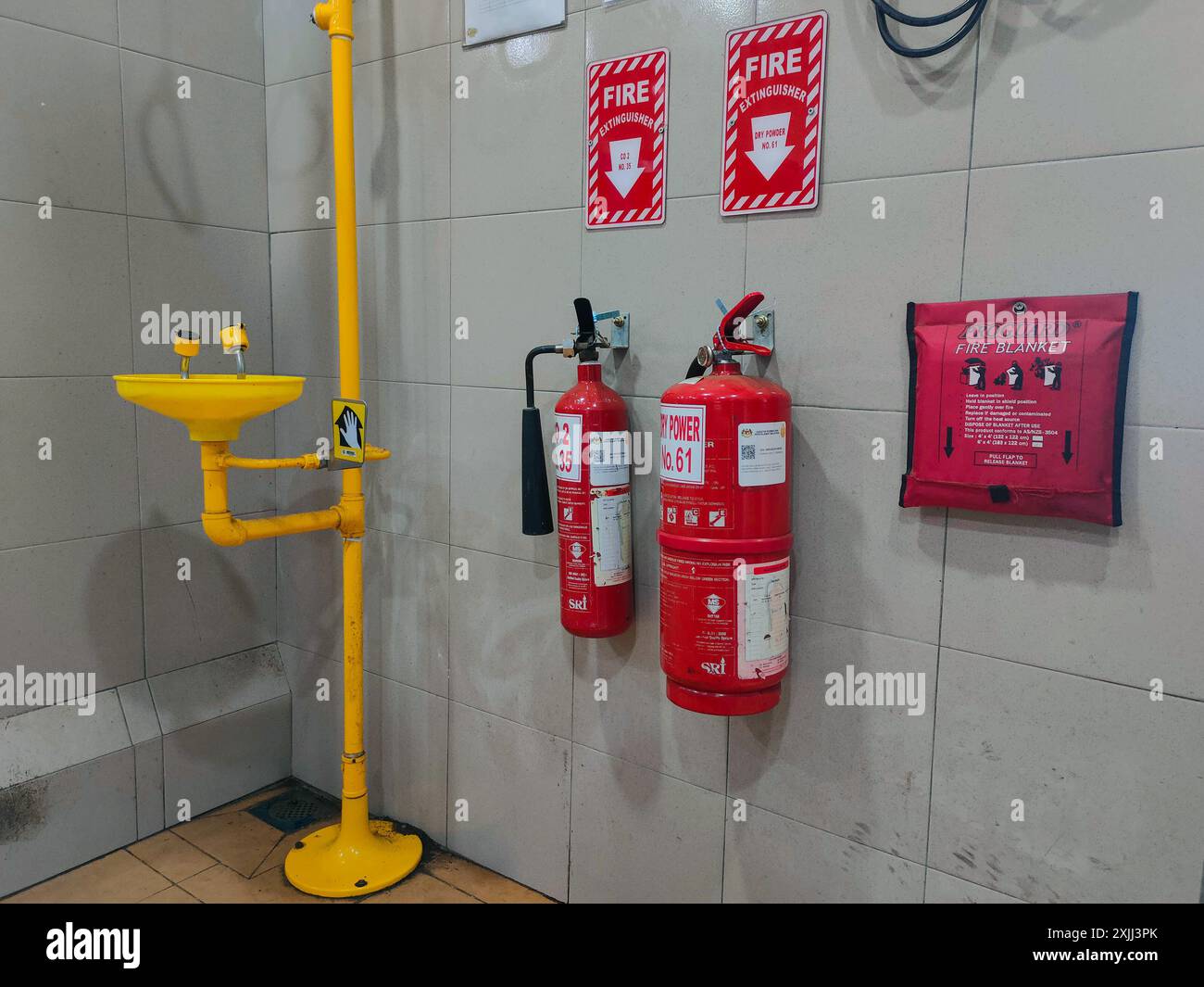 Lavaggio oculare ed estintore di emergenza polvere secca e co2 e coperta antincendio forniti in un locale di laboratorio Foto Stock