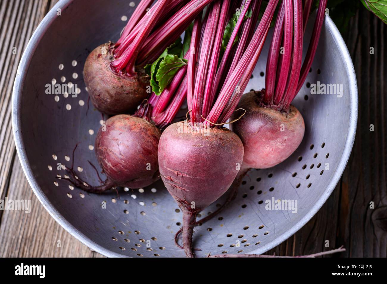 Barbabietole mature fresche su un colino metallico. Fotografia gastronomica Foto Stock