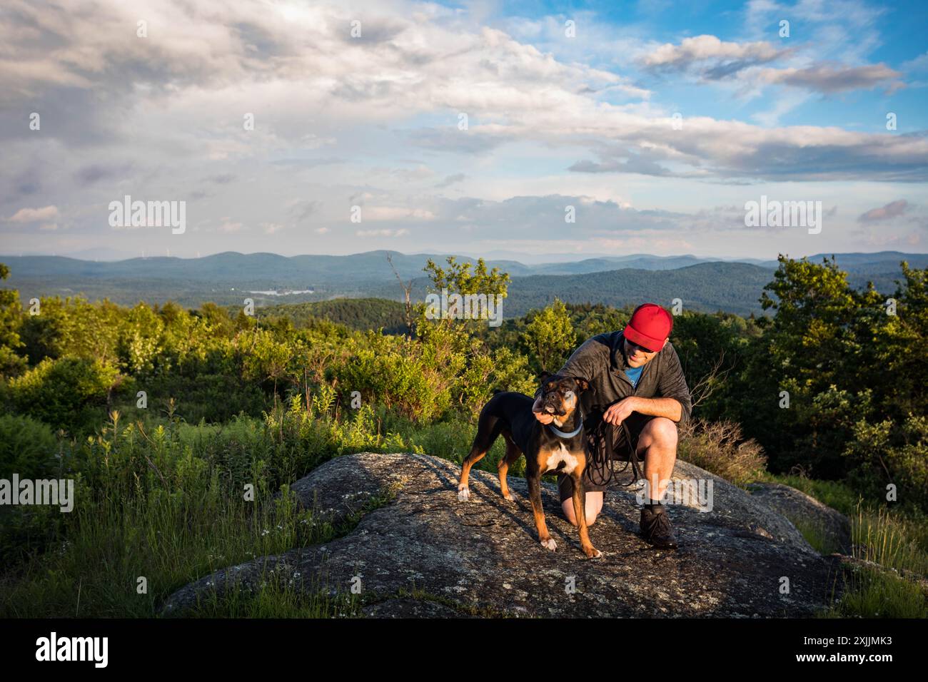 Uomo che accarezza il suo cane in un punto panoramico nel New Hampshire Foto Stock