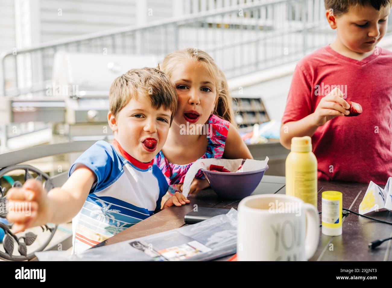 Bambini che amano le fragole durante una riunione estiva all'aperto. Foto Stock