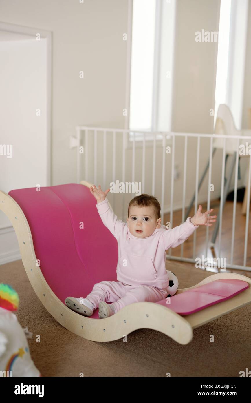 Bambina che gioca e posa su una palestra rosa all'interno Foto Stock