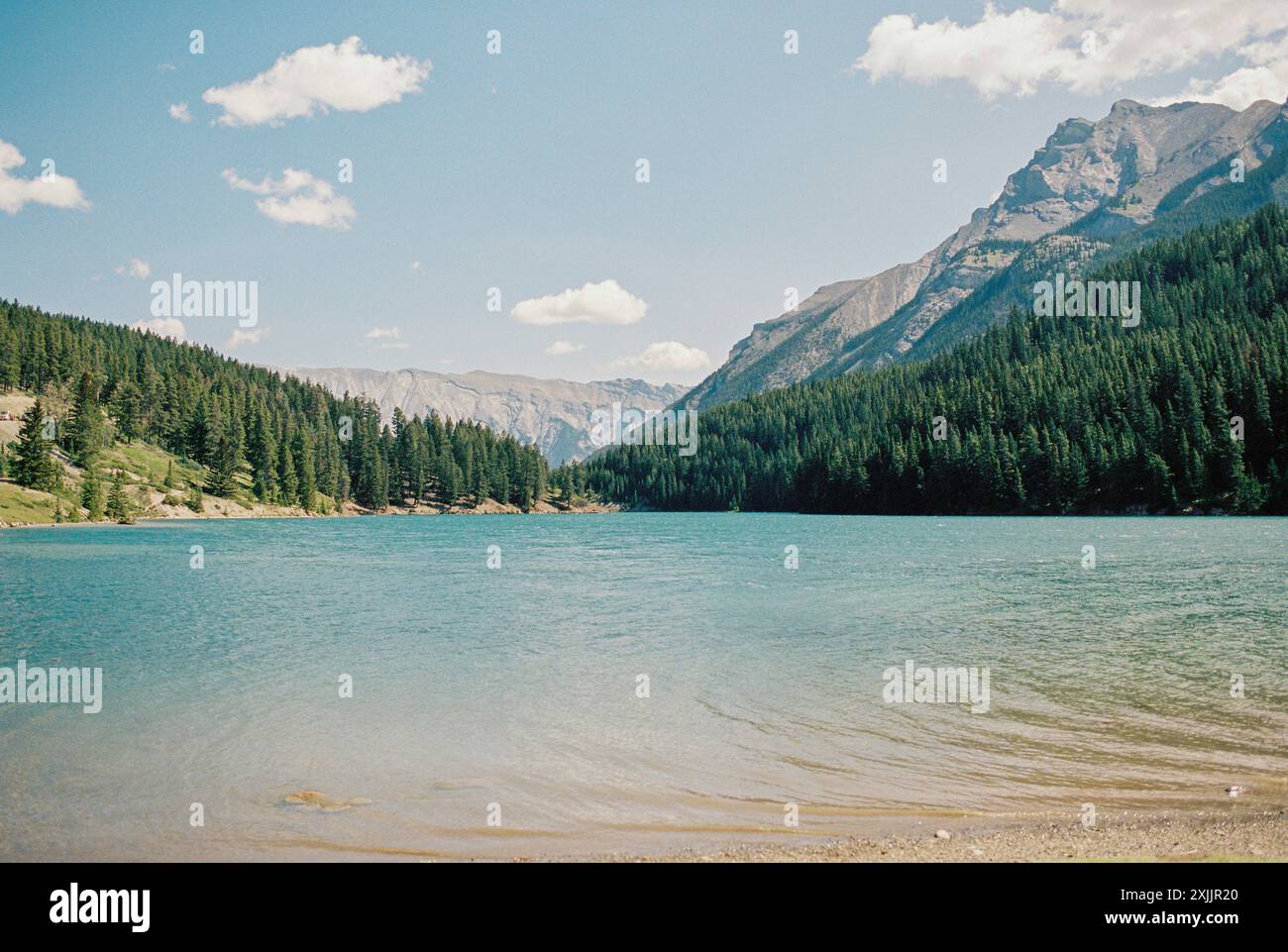 Tranquillo lago Minnewanka a Banff, Alberta con le montagne circostanti Foto Stock