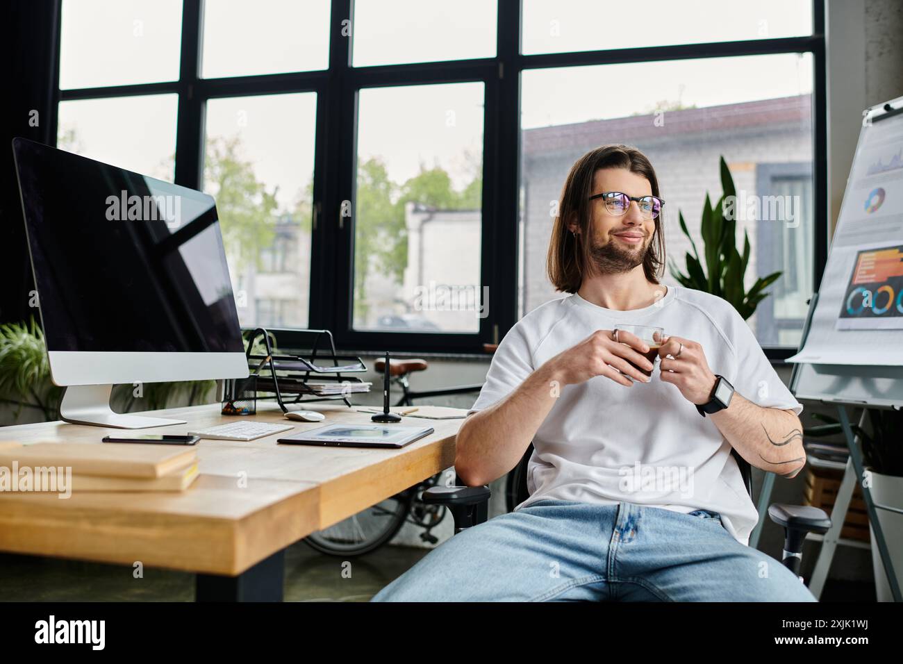 Un bell'uomo d'affari caucasico impegnato a lavorare su un computer alla sua scrivania. Foto Stock