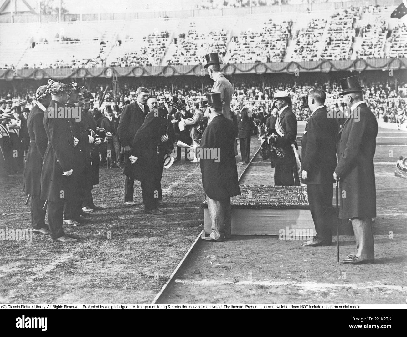 Re Gustavo V di Svezia, 1858-1950, assegna il primo premio alla squadra di rimorchiatore durante i Giochi Olimpici di Stoccolma in Svezia nel 1912. La squadra era composta da poliziotti svedesi, che furono dichiarati i vincitori finali dopo una sola partita. Foto Stock