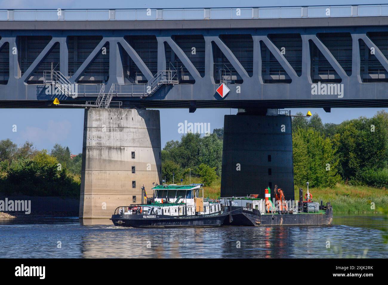 19 luglio 2024, Sassonia-Anhalt, Möser: Una nave passa sotto il ponte del canale di Magdeburgo. Il Ponte del Canale di Magdeburgo è costituito da un ponte lungo 690 metri e da un ponte lungo 228 metri. In totale, il ponte sul canale è lungo 918 metri. Trasporta il traffico marittimo sul canale Mittelland attraverso l'Elba ed è il ponte canale più lungo del mondo. La struttura fa parte dell'intersezione del corso d'acqua di Magdeburgo. Circa 68.000 metri cubi di cemento armato sono stati utilizzati per il ponte, oltre a 10.000 tonnellate di acciaio per il ponte sul fiume e 14.000 tonnellate di acciaio per il ponte sul territorio. Pho Foto Stock