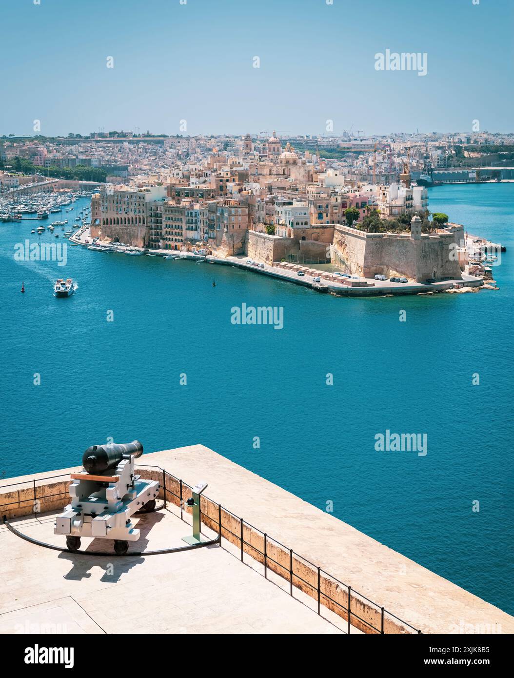 Una splendida vista aerea di una città fortificata con edifici storici, circondata da un porto con barche a Malta. Foto Stock