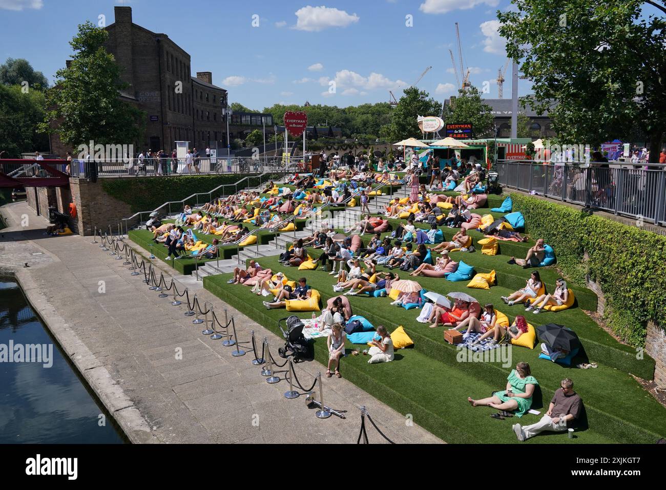 Gente che si gode il clima caldo a Granary Square, Londra. È probabile che l'Inghilterra sud-orientale vedrà il giorno più caldo dell'anno del Regno Unito fino ad ora venerdì, anche se il Regno Unito nel suo complesso si troverà di fronte a un quadro misto venerdì e nel fine settimana. Data foto: Venerdì 19 luglio 2024. Foto Stock