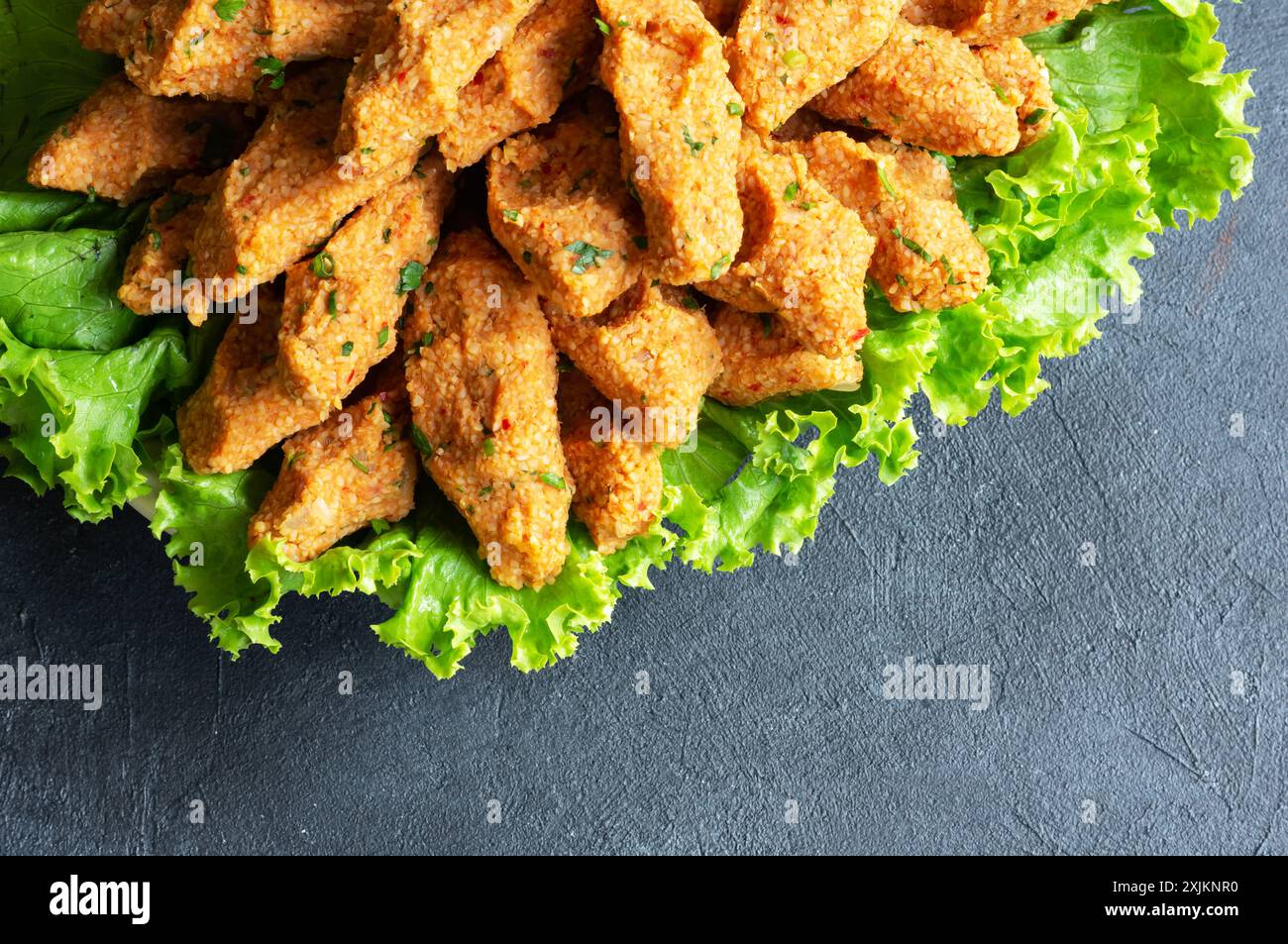 Polpette crude con lattuga su fondo rustico, carne cruda turca tradizionale ( cig kofte ) Foto Stock