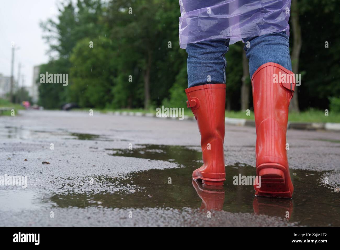 Donna con stivali di gomma rossi che cammina all'aperto, primo piano. Spazio per il testo Foto Stock