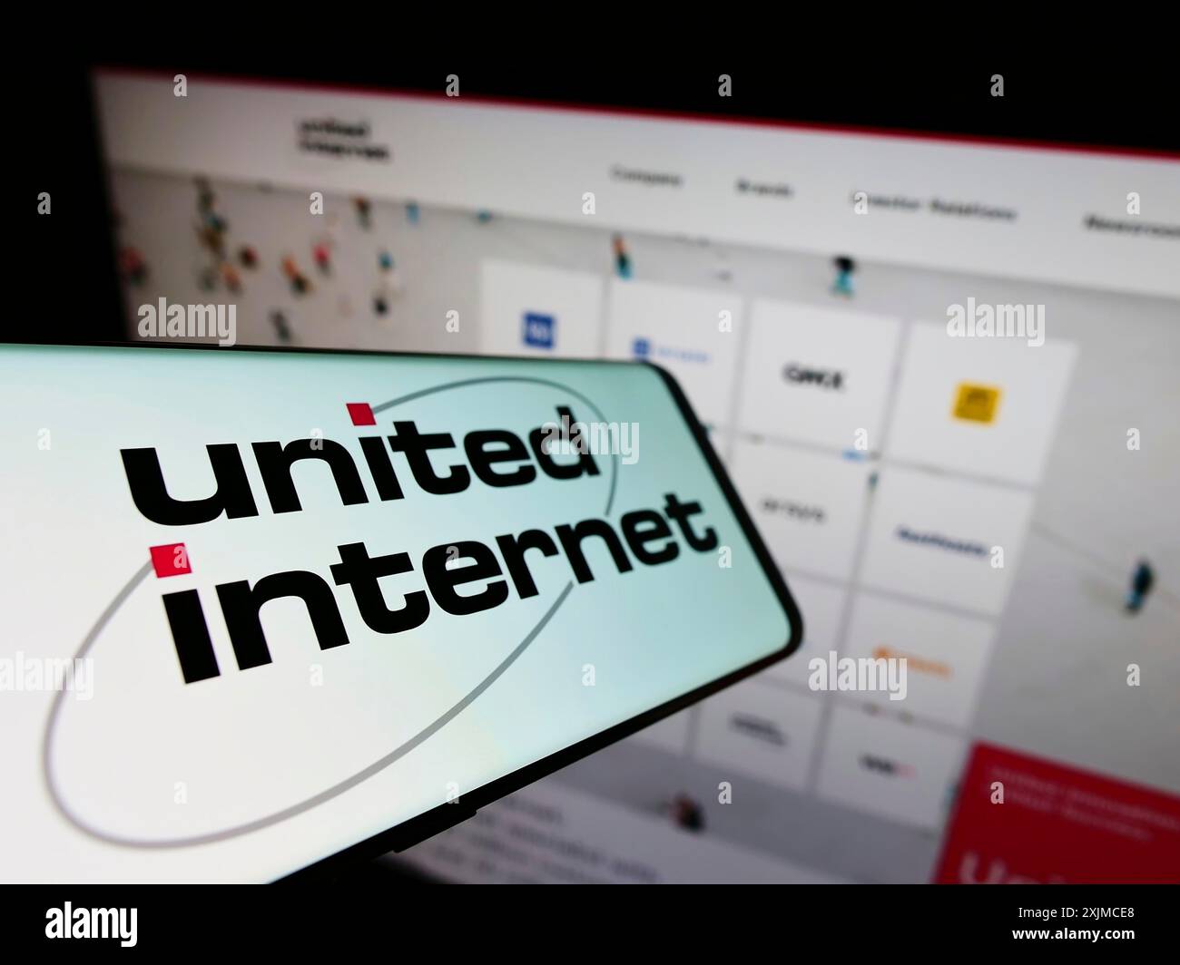 Stoccarda, Germania, 05-21-2022: Smartphone con logo della società tedesca United Internet AG sullo schermo di fronte al sito Web aziendale. Concentrati su Foto Stock