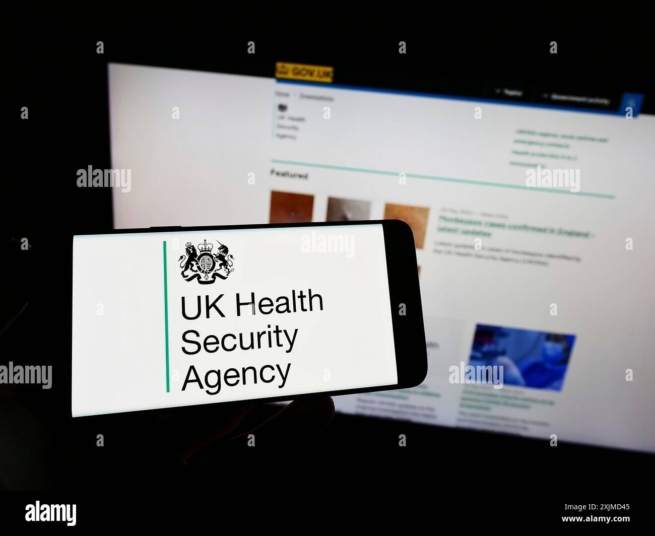 Stoccarda, Germania, 05-26-2022: Persona con smartphone con logo dell'agenzia UK Health Security Agency (UKHSA) sullo schermo davanti al sito web. Concentrati Foto Stock