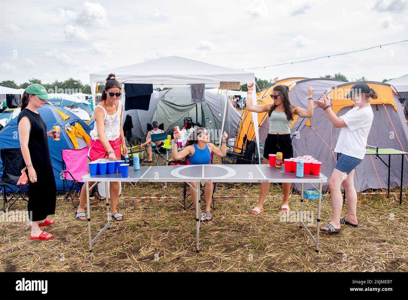 Nordholz, Germania. 19 luglio 2024. I visitatori del festival Madlen (l-r), Elena, Sina, Sinja e Sarah di Amburgo giocano al gioco del bere Beer Pong nel campeggio del Deichbrand Festival. Il festival all'aperto con circa 60.000 visitatori si svolge dal 18 al 21 luglio. Crediti: Hauke-Christian Dittrich/dpa/Alamy Live News Foto Stock