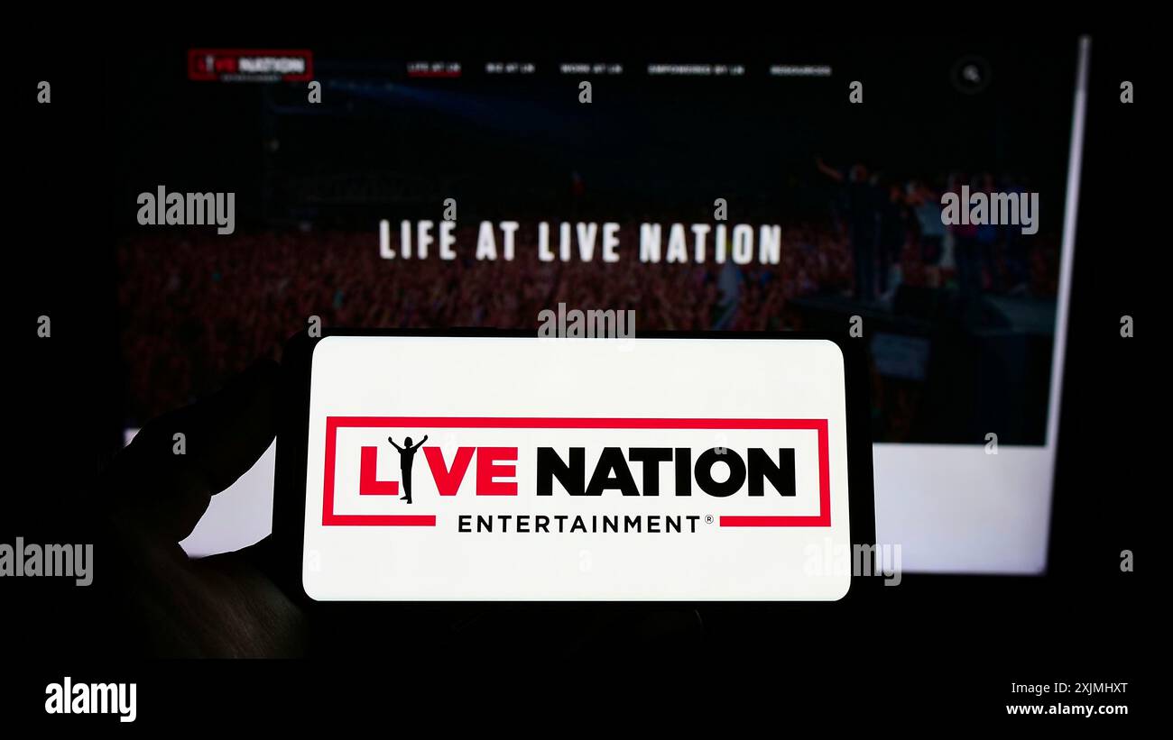 Stuttgart, Germania, 07-24-2022: Persona che possiede uno smartphone con il logo della società statunitense Live Nation Entertainment Inc. Sullo schermo davanti al sito Web. Concentrati Foto Stock