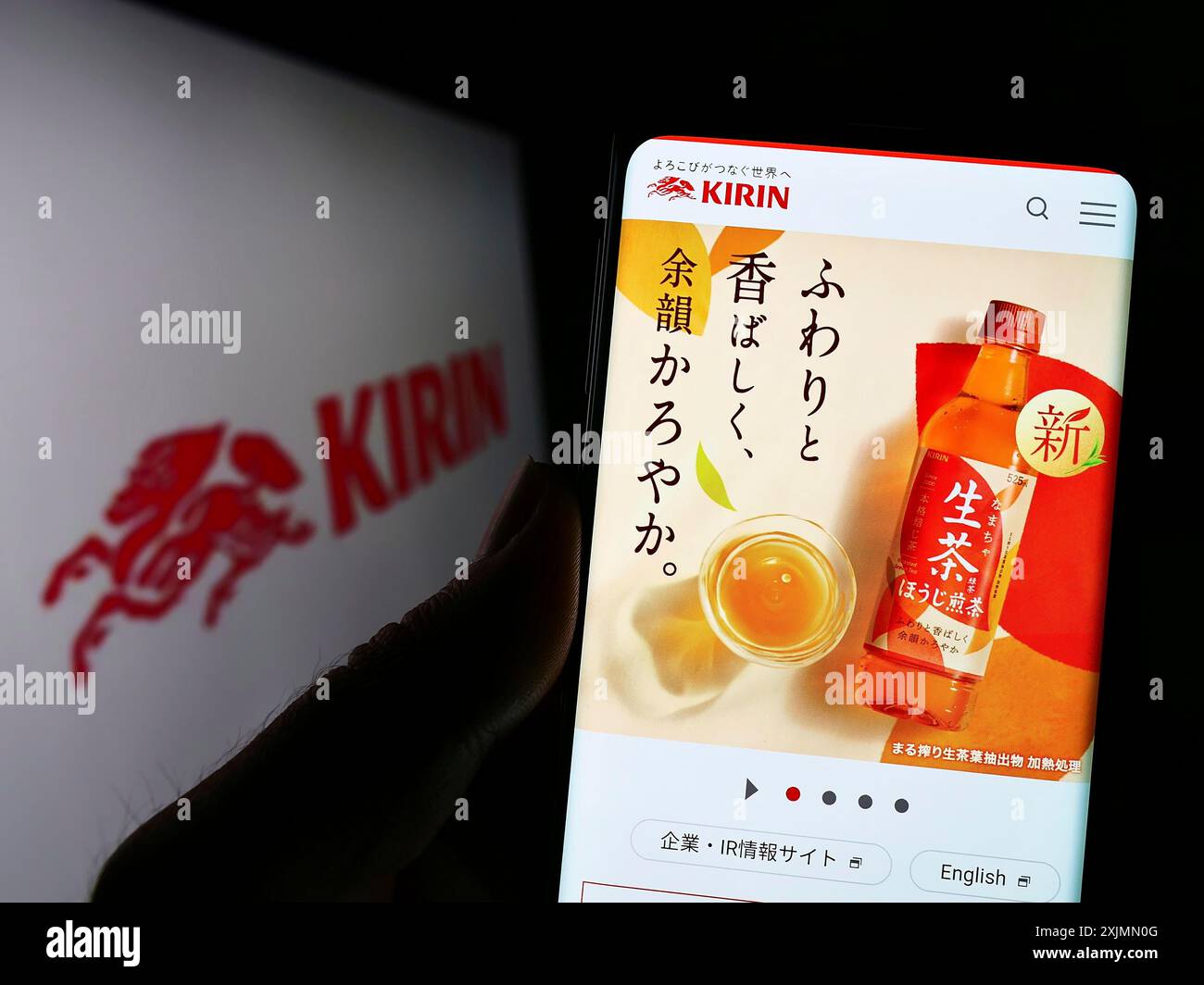 Telefono cellulare con sito web della Japanese Kirin Brewery Company Limited sullo schermo davanti al logo. Messa a fuoco al centro del display del telefono Foto Stock