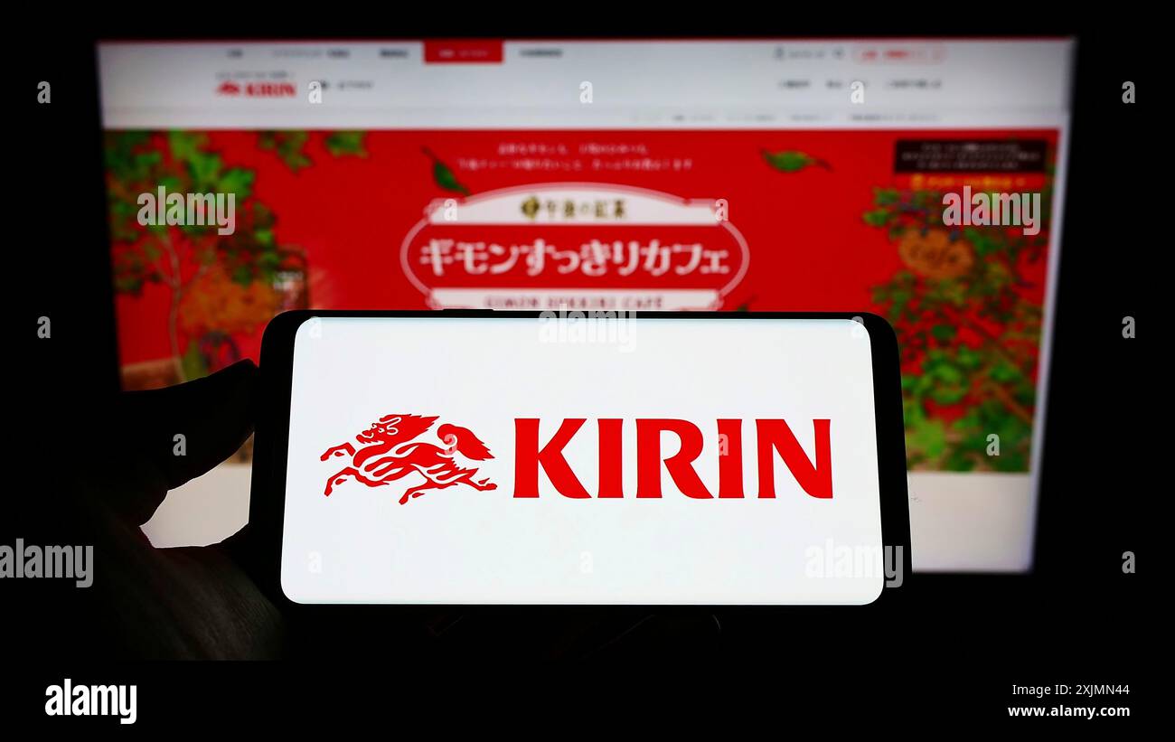 Telefono cellulare con logo della Japanese Kirin Brewery Company Limited sullo schermo di fronte alla pagina Web aziendale. Mettere a fuoco il display del telefono Foto Stock