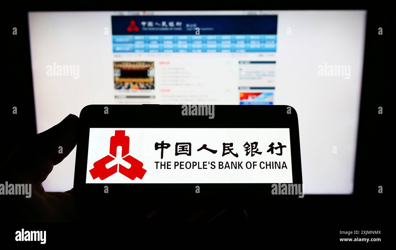 Stoccarda, Germania, 09-19-2022: Persona che tiene il cellulare con il logo dell'istituto finanziario People's Bank of China sullo schermo davanti alla pagina web. Foto Stock
