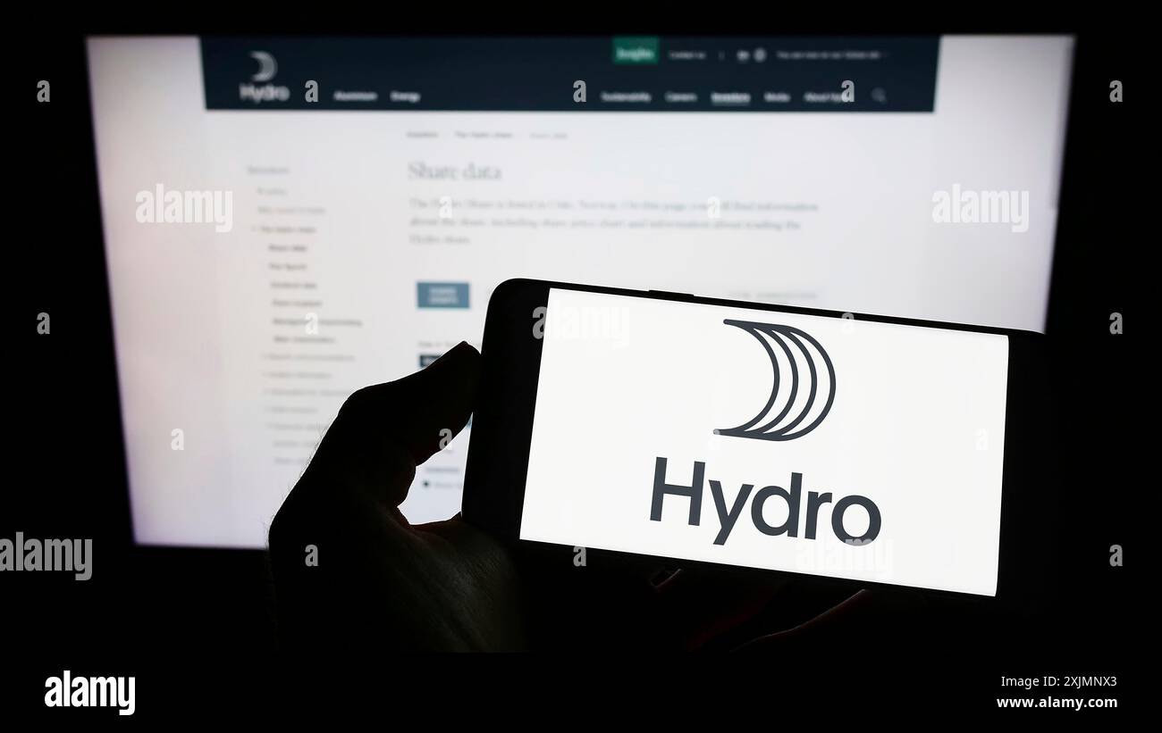 Stoccarda, Germania, 09-22-2022: Persona che detiene uno smartphone con il logo della società norvegese di alluminio Norsk Hydro ASA sullo schermo di fronte al sito web. Foto Stock