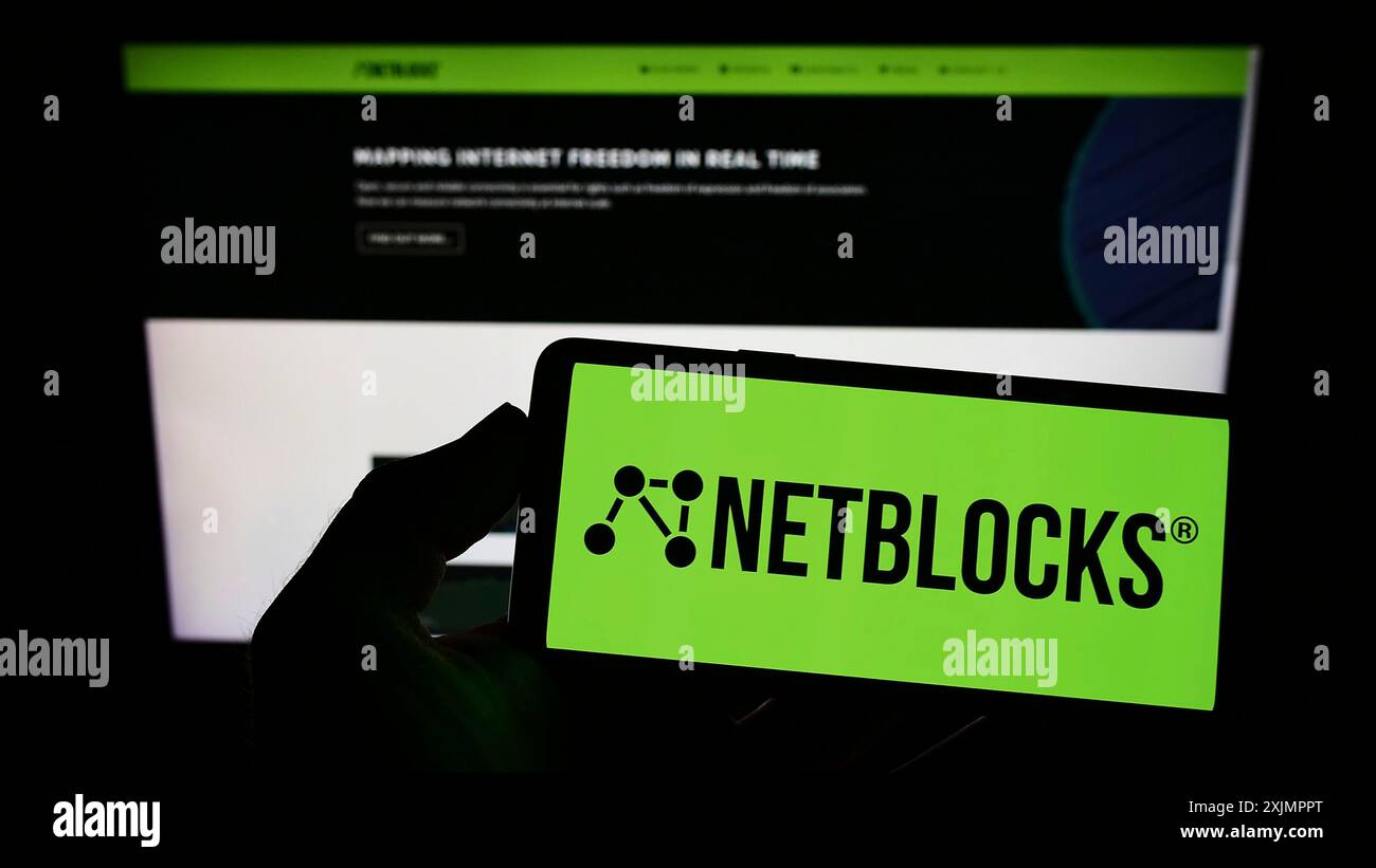 Stoccarda, Germania, 10-01-2022: Persona con smartphone con logo di Internet Watchdog NetBlocks Ltd. Sullo schermo di fronte al sito web. Concentrati sul telefono Foto Stock