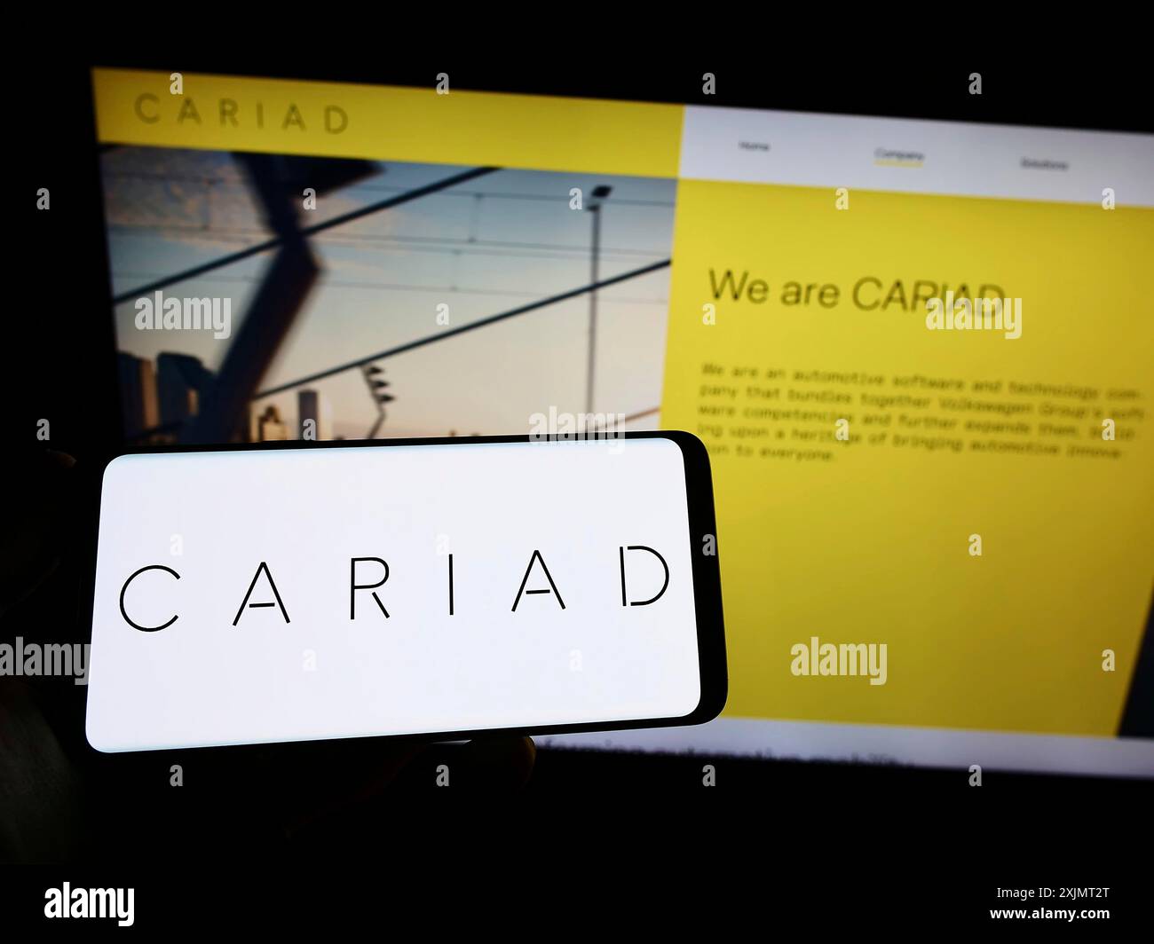 Stoccarda, Germania, 10-15-2022: Persona che possiede uno smartphone con il logo della società tedesca di software automobilistico Cariad se sullo schermo davanti al sito web. Foto Stock