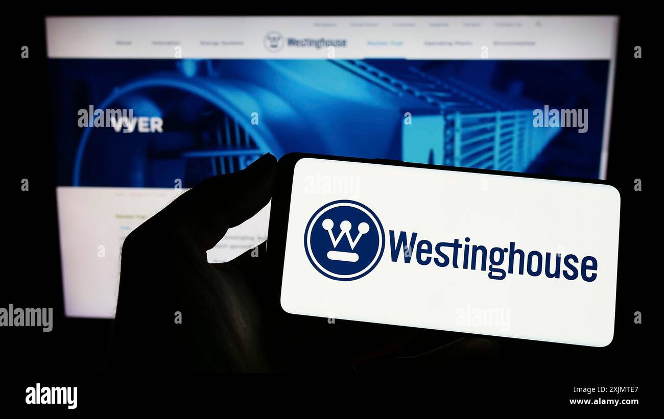 Stoccarda, Germania, 10-26-2022: Persona che tiene il cellulare con il logo di Westinghouse Electric Company LLC sullo schermo davanti alla pagina web aziendale. Concentrati Foto Stock