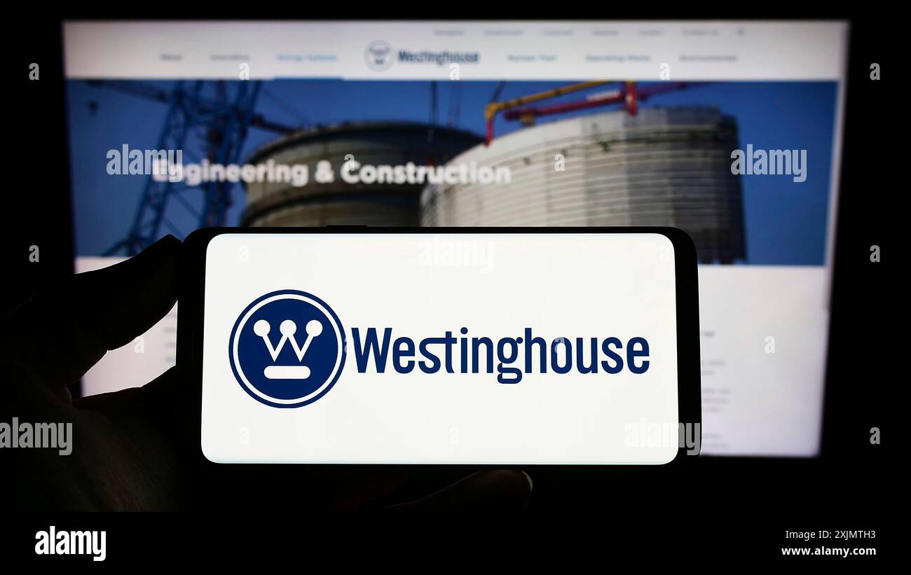 Stoccarda, Germania, 10-26-2022: Persona che detiene un telefono cellulare con il logo di Westinghouse Electric Company LLC sullo schermo di fronte alla pagina web aziendale. Foto Stock