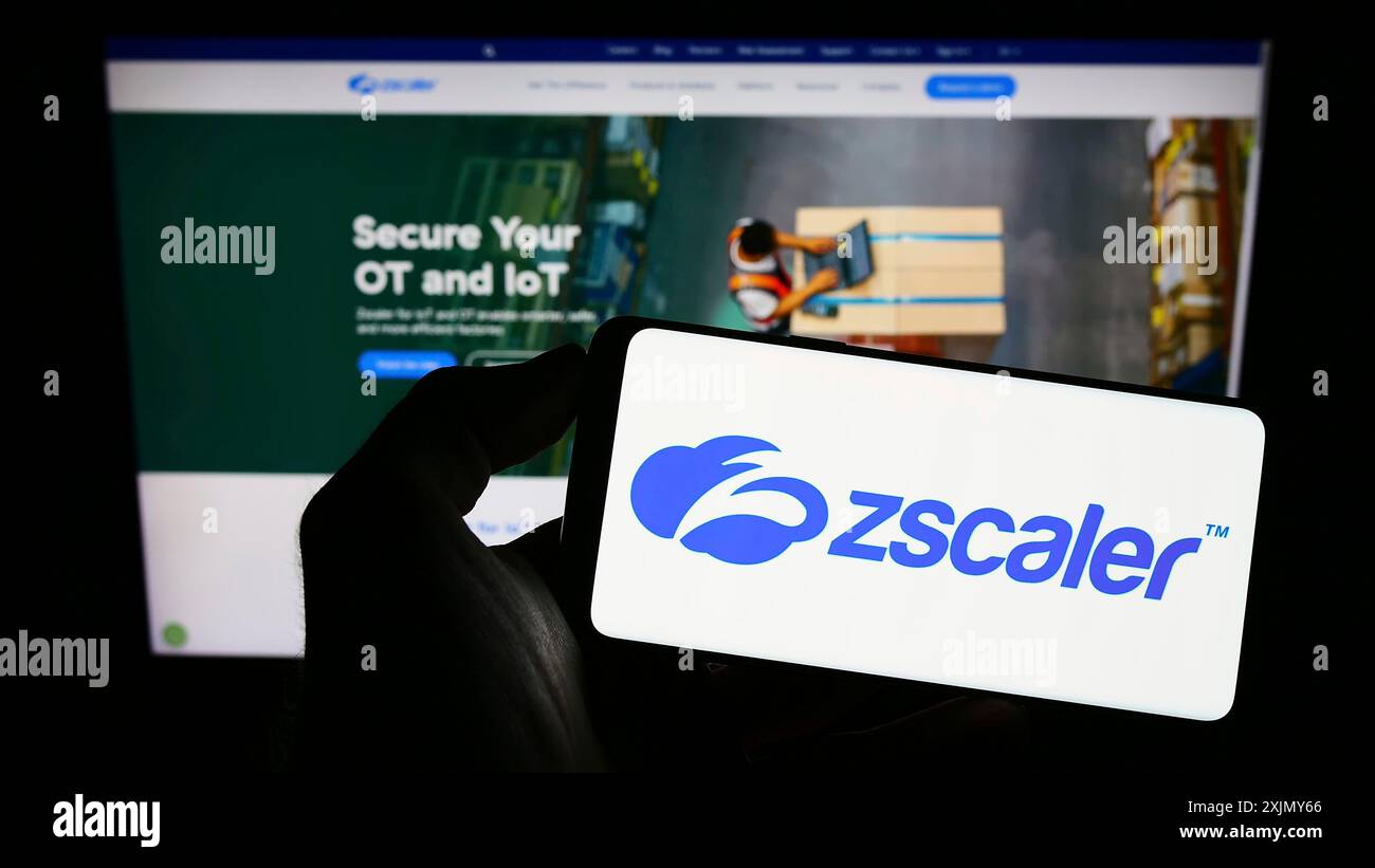 Stoccarda, Germania, 12-30-2022: Persona con smartphone con logo della società statunitense di sicurezza sul cloud Zscaler Inc. Sullo schermo davanti al sito Web. Concentrati su Foto Stock