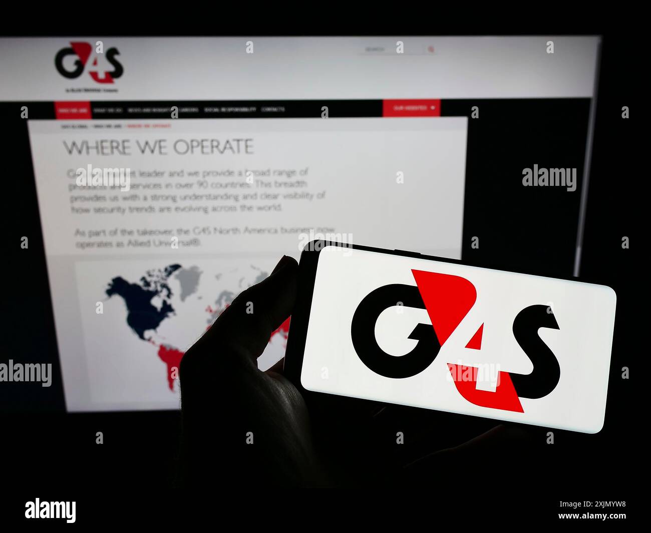 Stoccarda, Germania, 12-25-2022: Persona con smartphone con logo della società britannica di sicurezza privata G4S Limited sullo schermo di fronte al sito web. Foto Stock