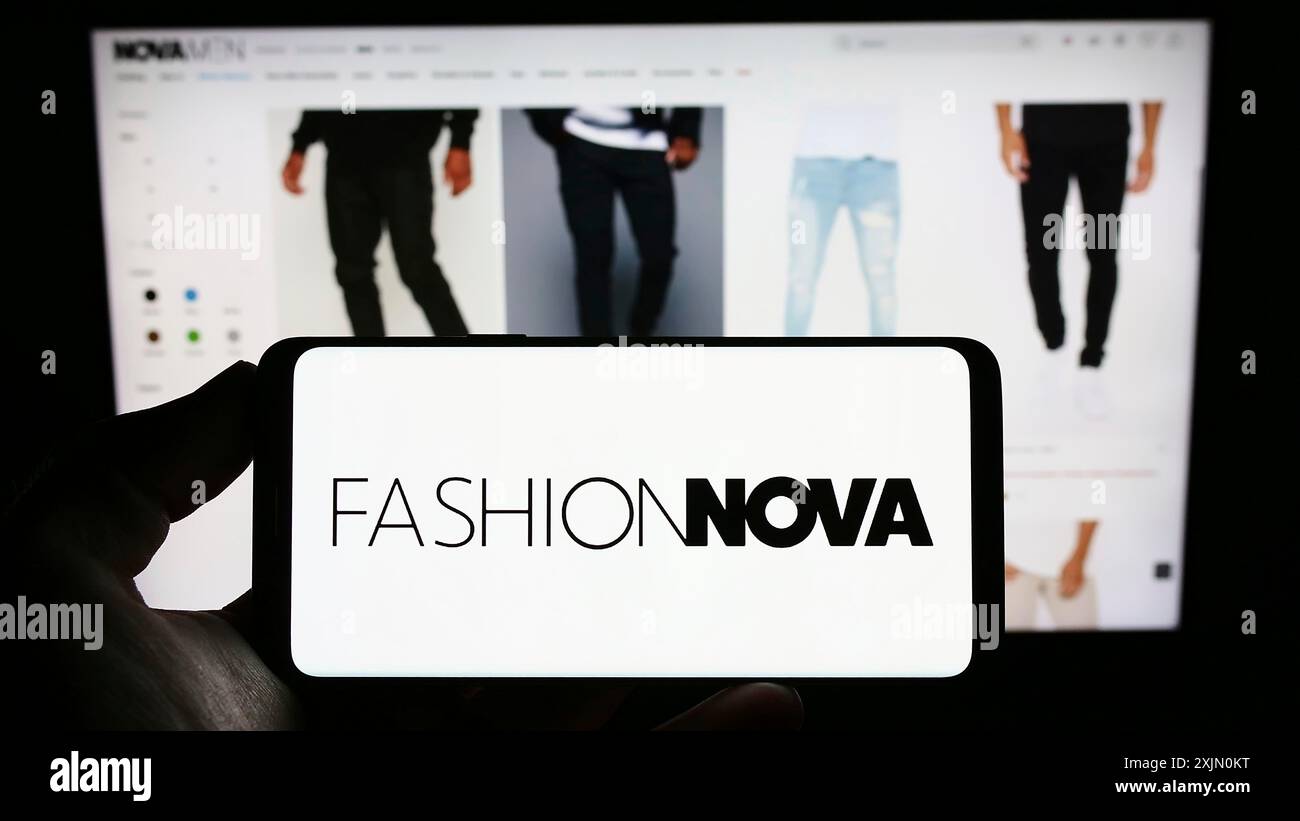 Stoccarda, Germania, 01-14-2023: Persona che detiene il cellulare con il logo della società di e-commerce statunitense Fashion Nova Inc. Sullo schermo di fronte alla pagina web aziendale. Foto Stock