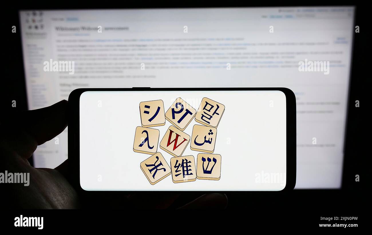Stoccarda, Germania, 01-15-2023: Persona che tiene un cellulare con il logo del dizionario online Wiktionary (Wikimedia) sullo schermo davanti alla pagina web. Concentrati Foto Stock