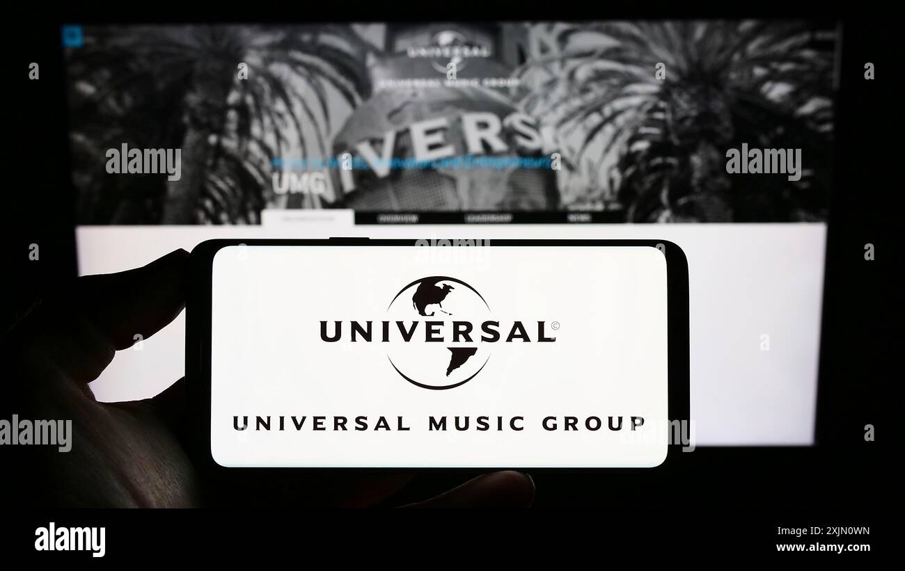 Stoccarda, Germania, 01-15-2023: Persona che detiene uno smartphone con il logo della società Universal Music Group N.V. (UMG) sullo schermo davanti al sito web. Concentrati Foto Stock