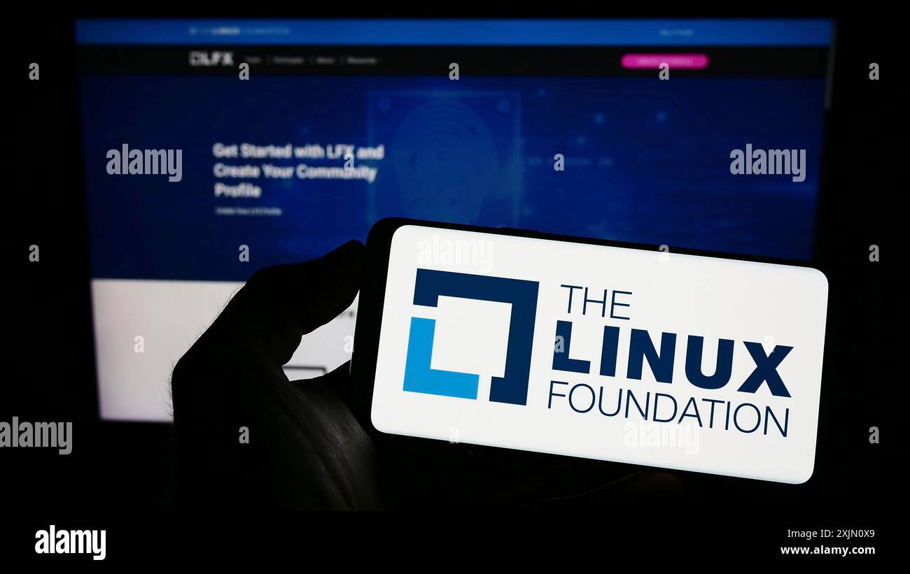 Stoccarda, Germania, 01-14-2023: Persona che detiene un telefono cellulare con il logo del consorzio tecnologico Linux Foundation sullo schermo di fronte alla pagina web. Concentrati Foto Stock