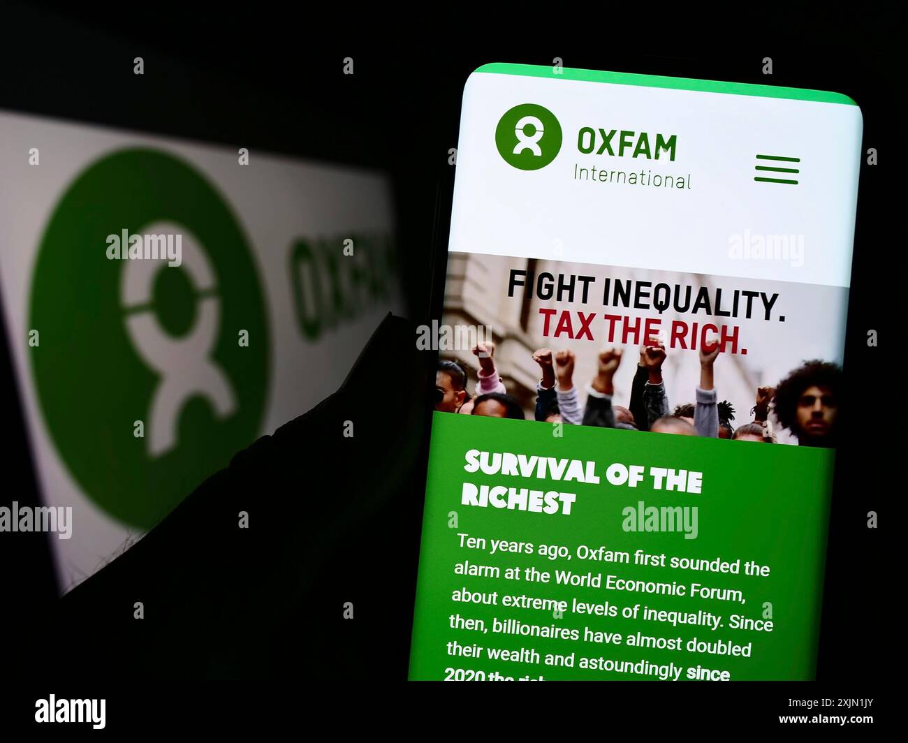 Stoccarda, Germania, 01-21-2023: Persona che possiede uno smartphone con il sito web confederation Oxfam International sullo schermo davanti al logo. Concentrati su Foto Stock