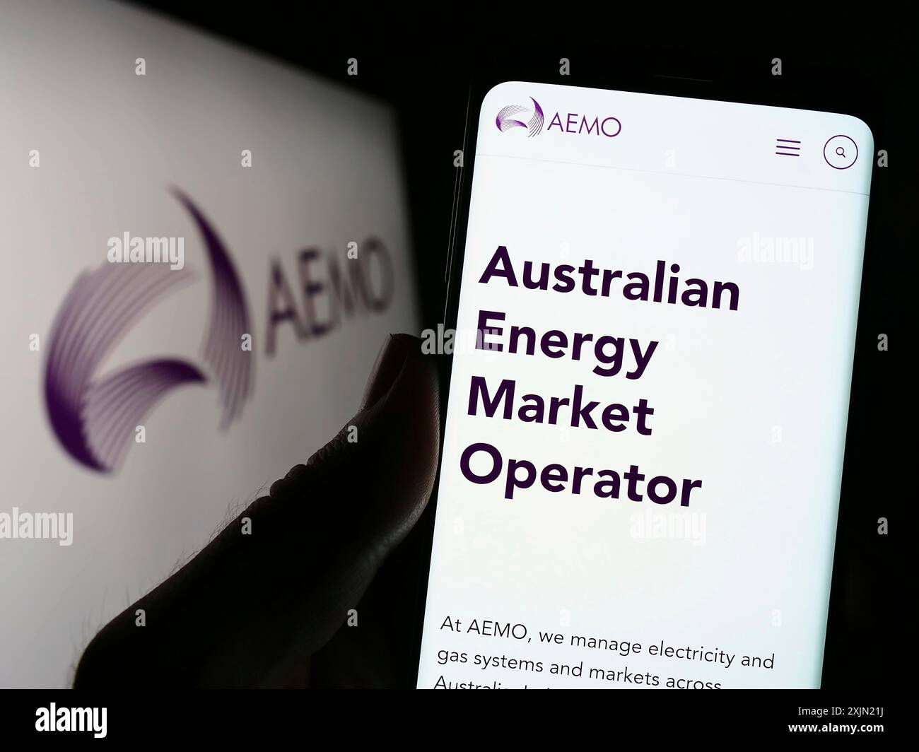 Stoccarda, Germania, 01-27-2023: Persona che detiene un telefono cellulare con il sito web dell'operatore australiano del mercato dell'energia (AEMO) sullo schermo davanti al logo. Foto Stock