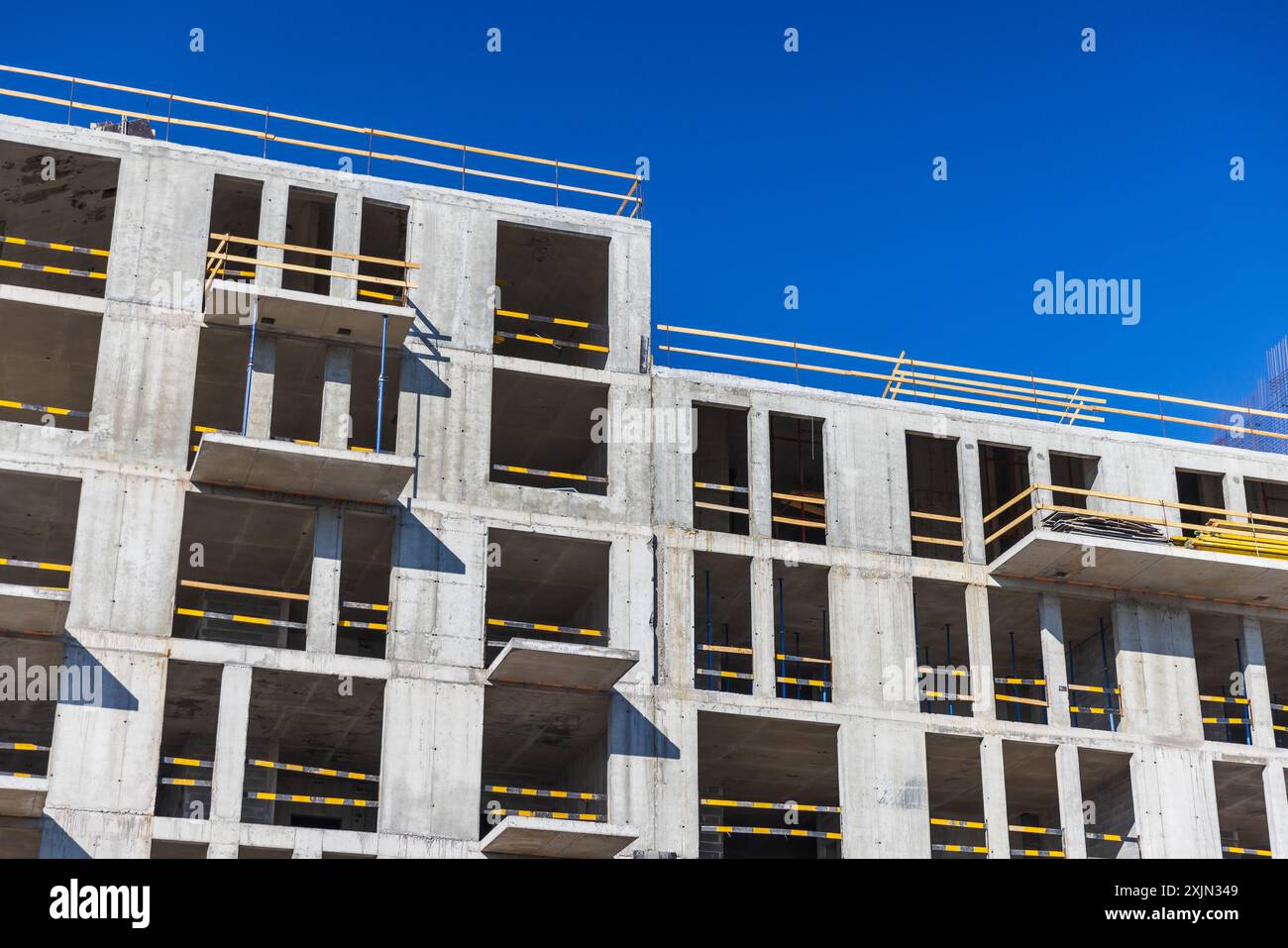 Casa moderna con facciata in cemento e' in costruzione sotto il cielo blu in una giornata di sole Foto Stock