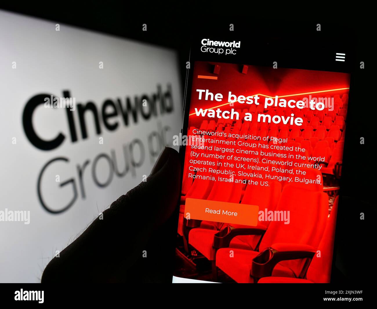Stoccarda, Germania, 03-19-2023: Persona che possiede uno smartphone con pagina web della società cinematografica britannica Cineworld Group plc sullo schermo davanti al logo. Foto Stock