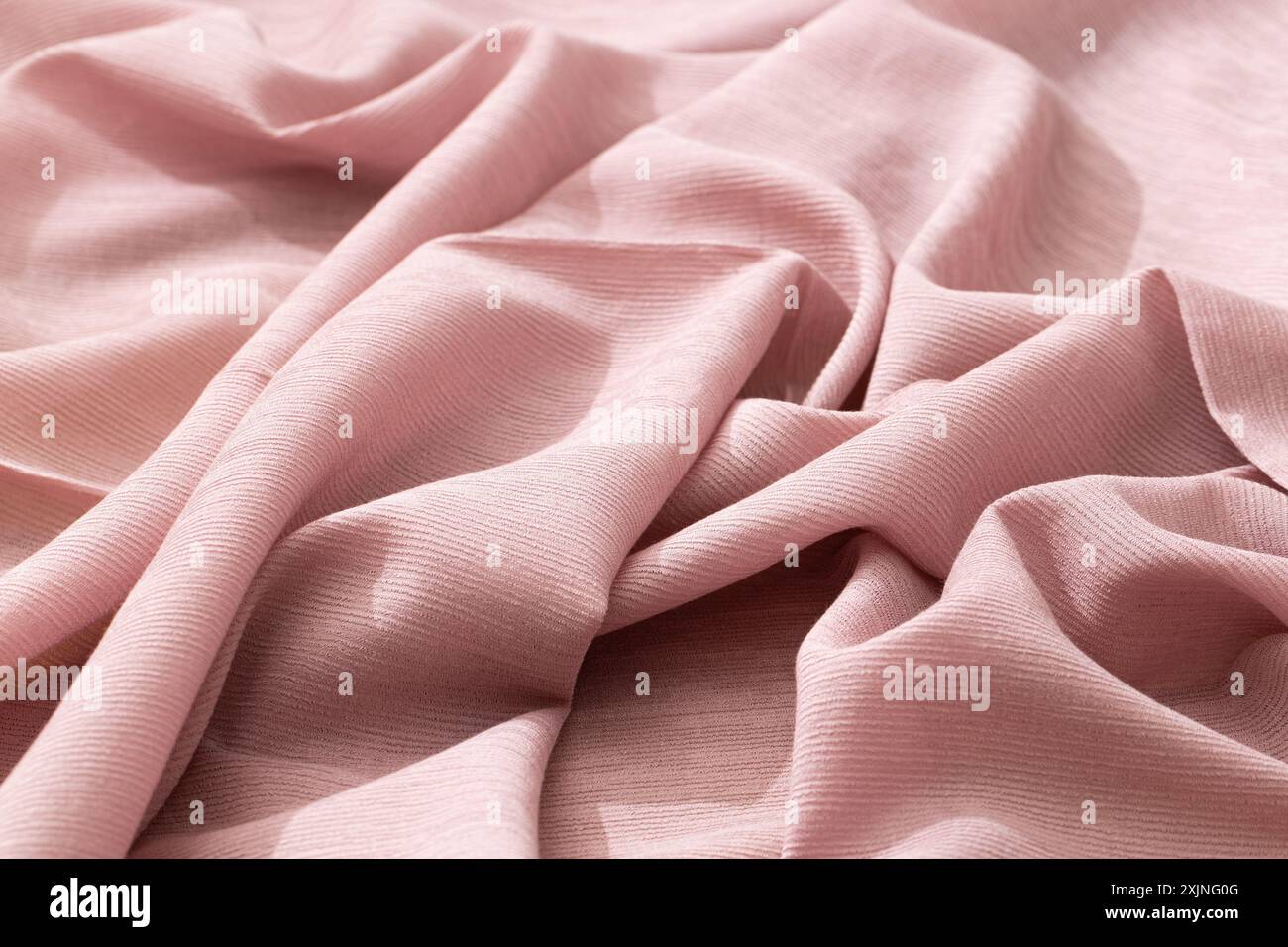 Tessuto rosa morbido ed elegante con una texture delicata, ideale per la moda e l'arredamento. Foto Stock