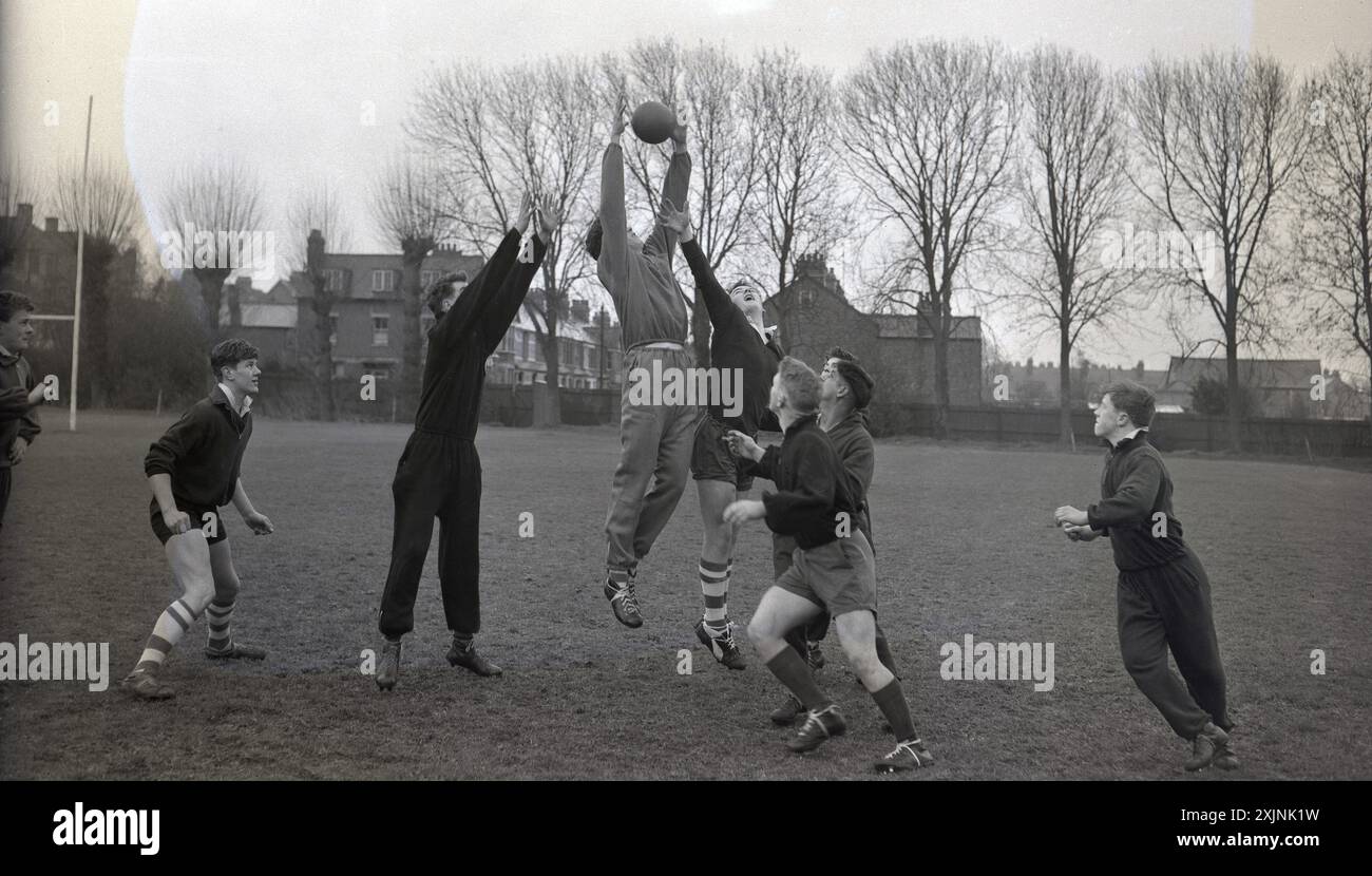 anni '1950, storica, rugby amatoriale, giocatori, alcuni indossano tute, gareggiare a una line-out per la palla in una sessione di allenamento, Inghilterra, Regno Unito. Foto Stock