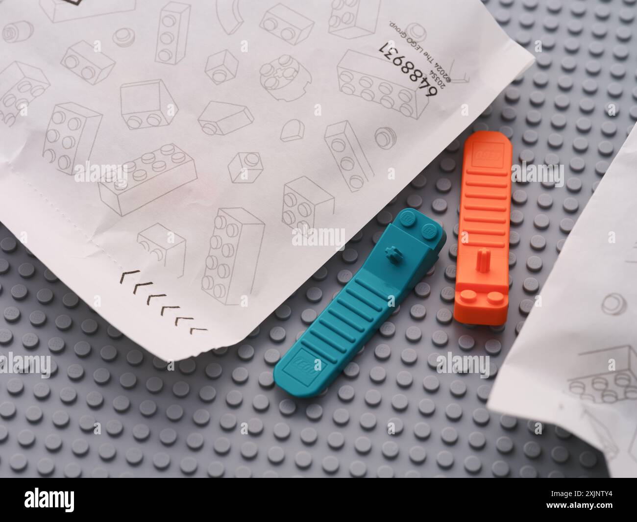 Tambov, Federazione Russa - 22 giugno 2024 separatori di mattoni Lego posti tra sacchetti di carta con pezzi Lego su una piastra di base grigia Foto Stock