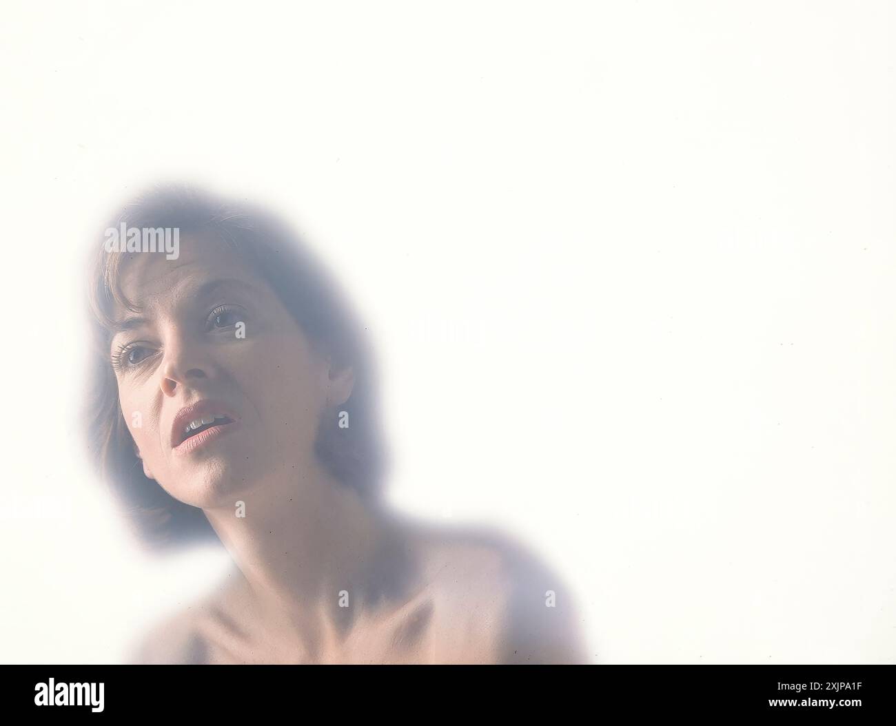 Ritratto di una donna con un'espressione dolorosa su sfondo bianco Foto Stock