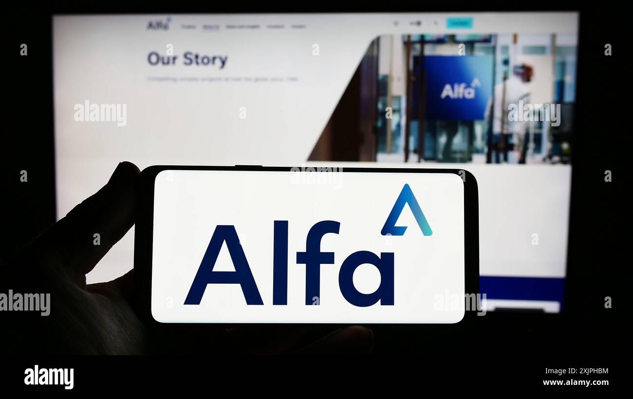 Stoccarda, Germania, 06-18-2023: Persona che detiene uno smartphone con logo della società Alfa Financial software Holdings plc sullo schermo davanti al sito web. Foto Stock