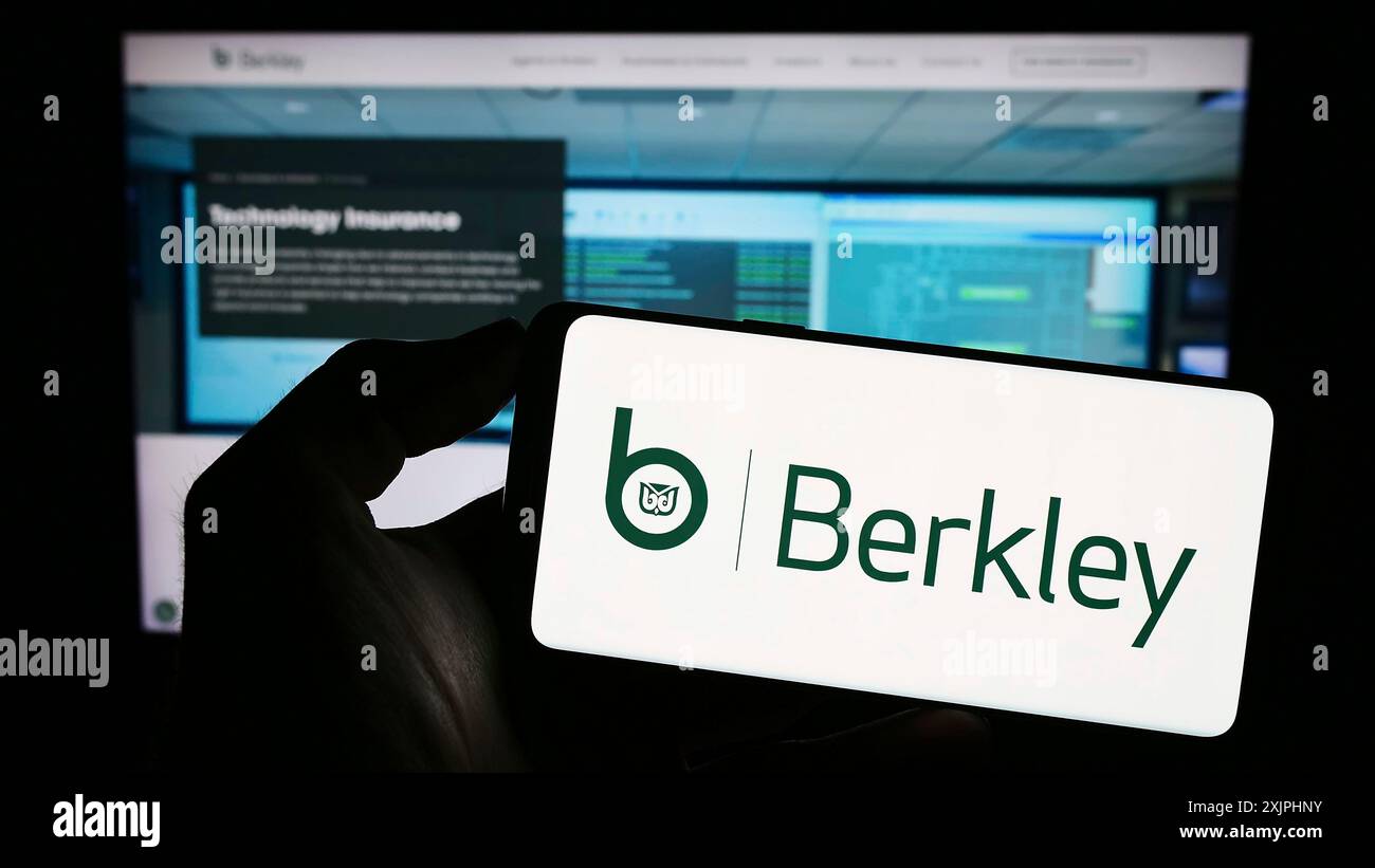 Stoccarda, Germania, 06-24-2023: Persona che detiene il cellulare con il logo della compagnia assicurativa americana WR Berkley Corporation sullo schermo di fronte Foto Stock