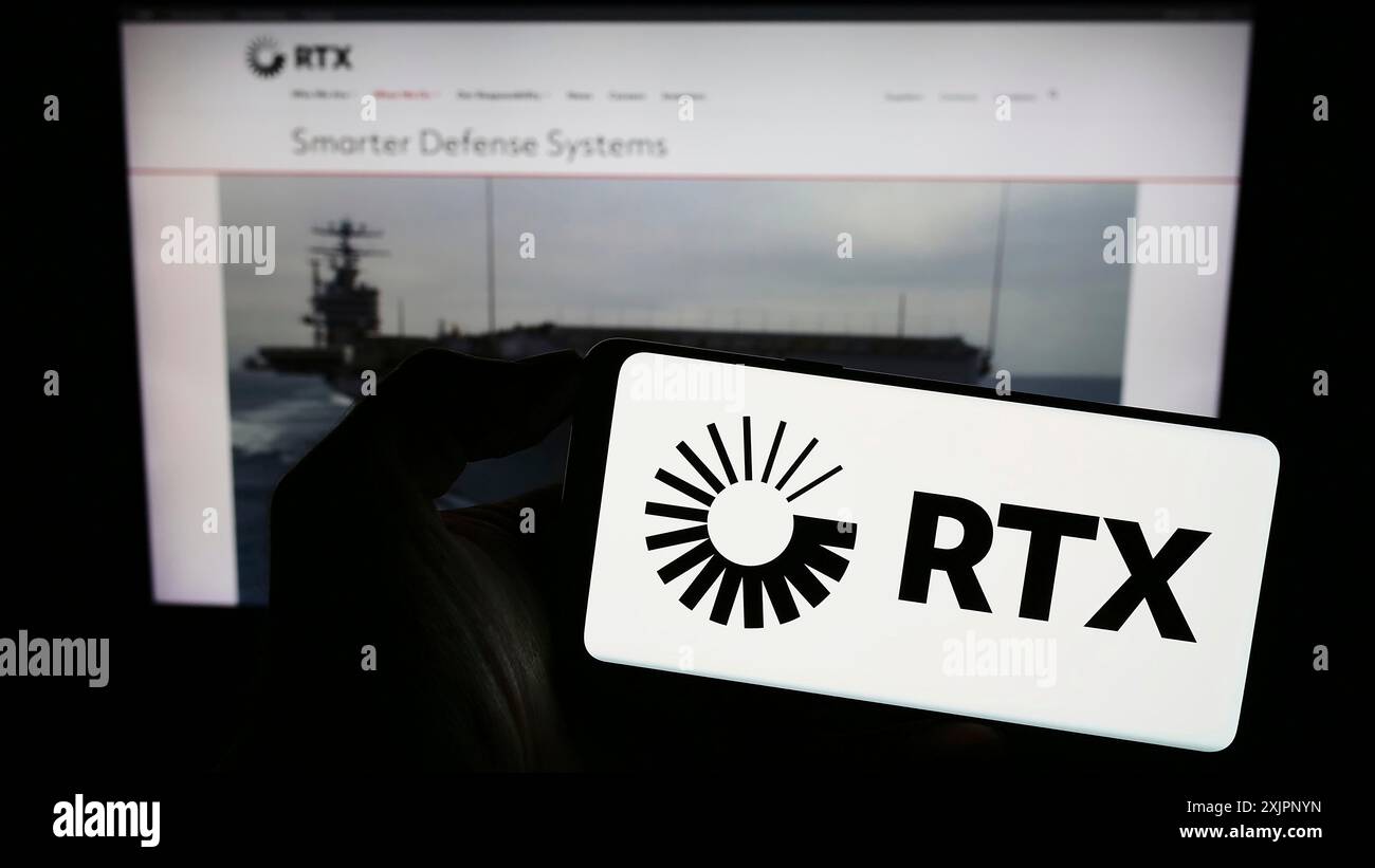 Stoccarda, Germania, 08-06-2023: Persona che detiene un telefono cellulare con il logo della società statunitense di aerospaziale e difesa RTX Corporation sullo schermo di fronte al web Foto Stock