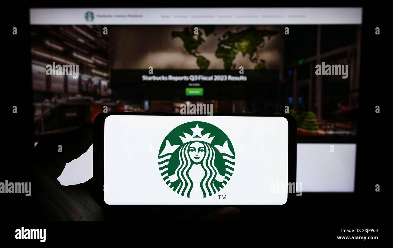 Stoccarda, Germania, 08-09-2023: Persona che tiene un cellulare con il logo della società americana Starbucks Corporation sullo schermo di fronte Foto Stock