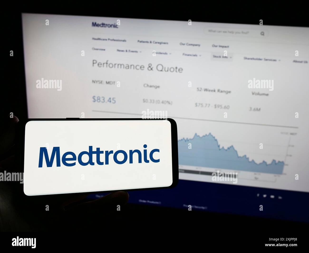 Stoccarda, Germania, 08-14-2023: Persona che detiene un telefono cellulare con il logo della società di tecnologia medica Medtronic plc sullo schermo di fronte al business web Foto Stock