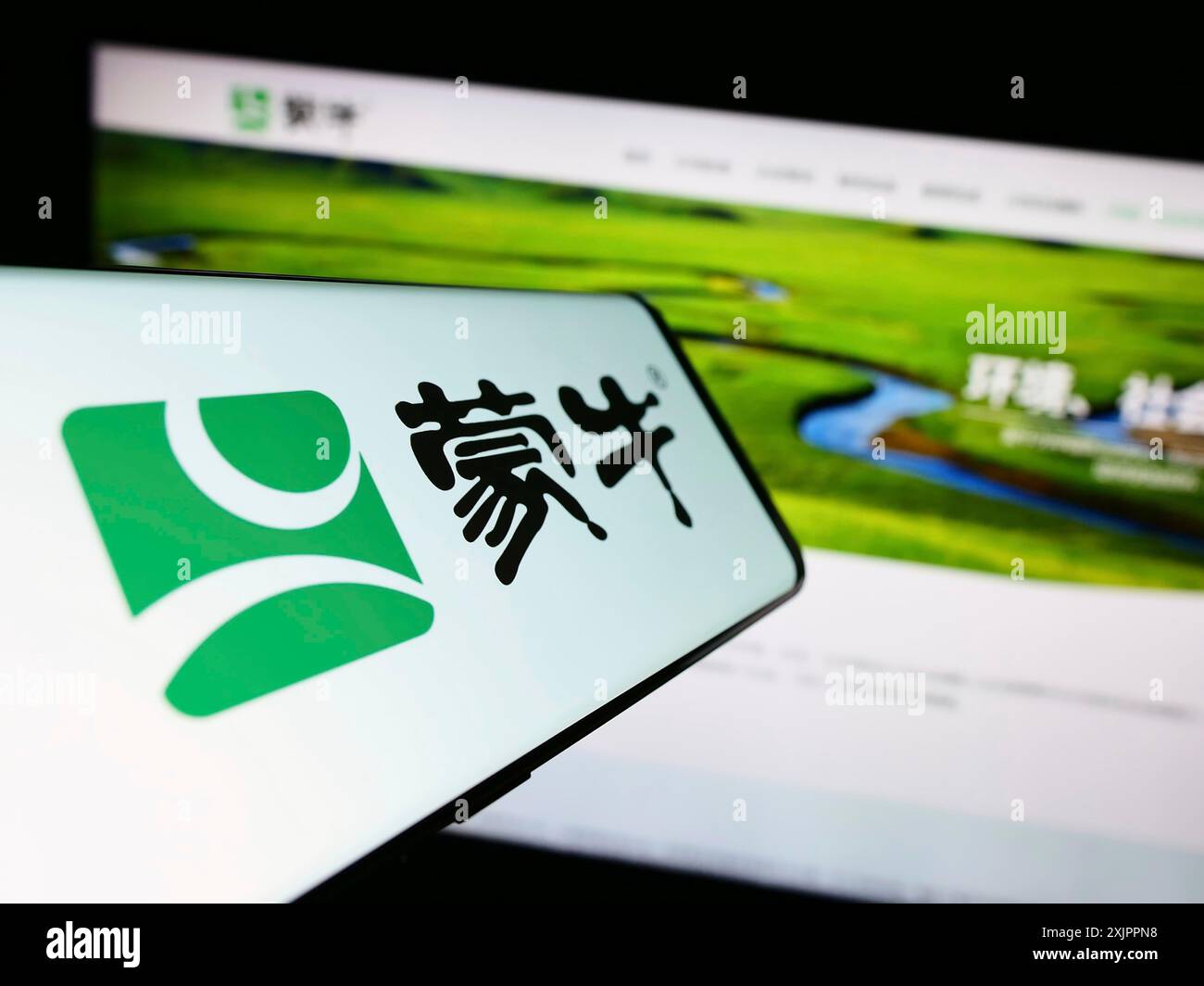 Stoccarda, Germania, 08-16-2023: Smartphone con logo China Mengniu Dairy Company Limited sullo schermo davanti al sito Web aziendale. Concentrati sul centro Foto Stock