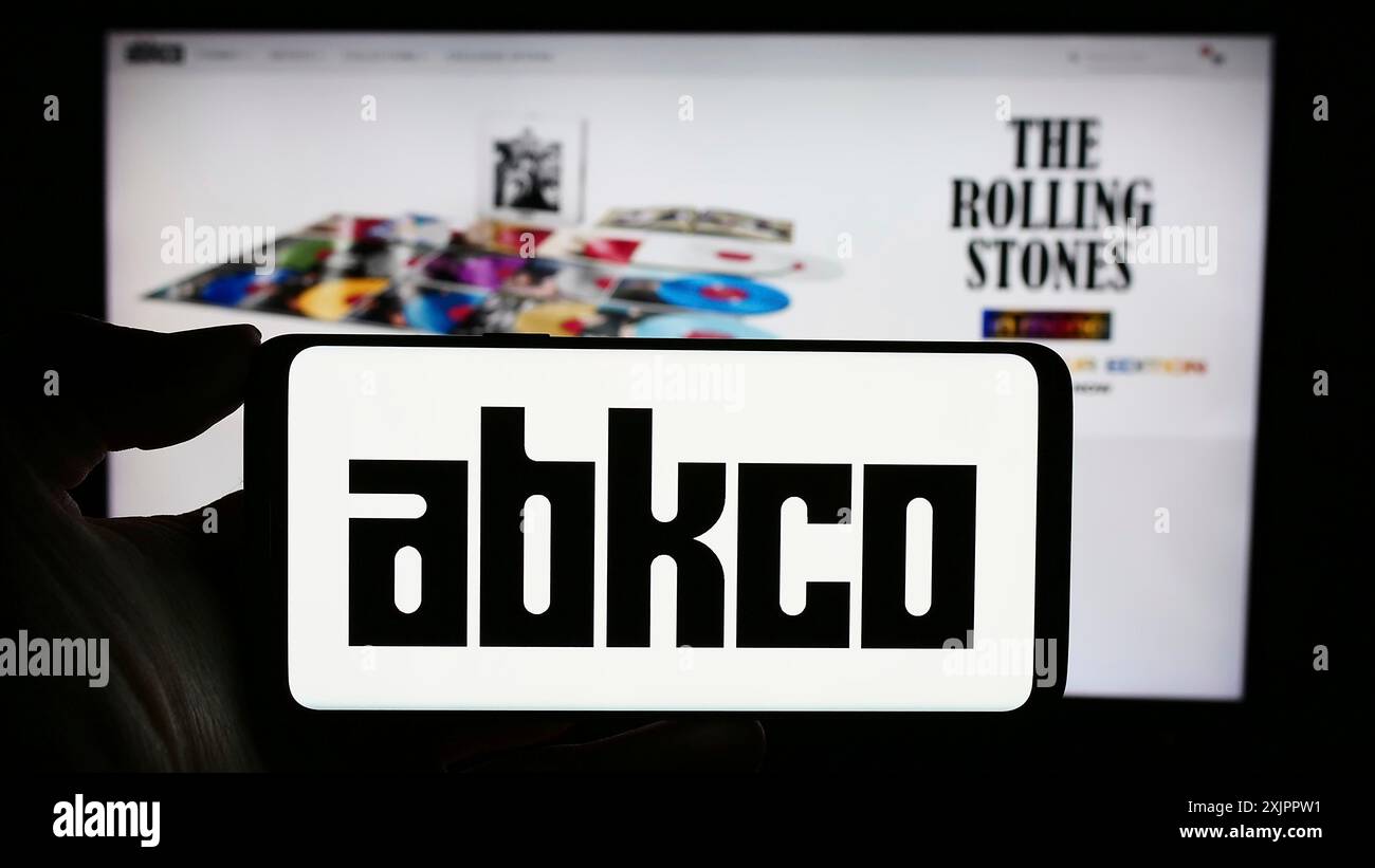 Stoccarda, Germania, 11-07-2023: Persona che detiene un telefono cellulare con il logo della casa discografica americana ABKCO Music Records Inc. Davanti alla pagina web. Foto Stock